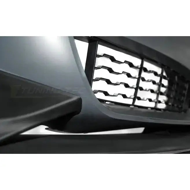 Frontbumper BMW F32/F33/F36 M-Performance style med svart grill og geometrisk mønster, sett fra siden.