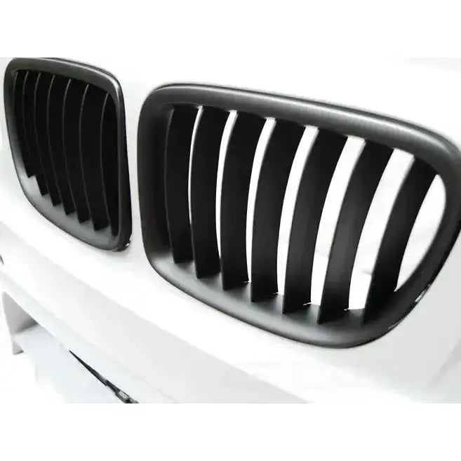 Frontfanger BMW X1 E84 M-Pack med to svarte grillrister i plast, matt finish, sett fra skrå vinkel.
