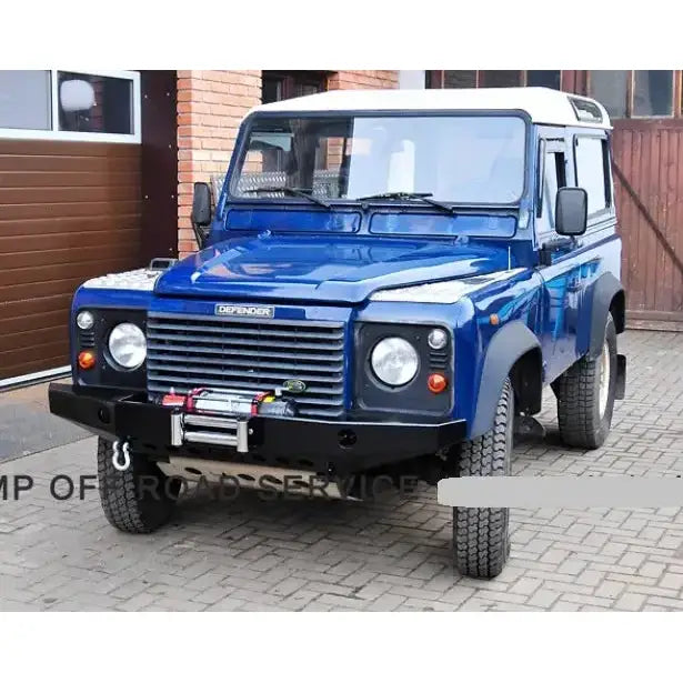 Frontfanger på Land Rover Defender med metallvinsj og krok, mørkeblå bil med hvitt tak sett skrått forfra.