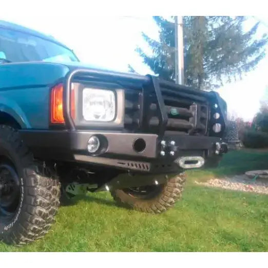 Frontfanger til Land Rover Discovery I med bullbar, vinsjfeste og runde tåkelys, montert på terrengbil.