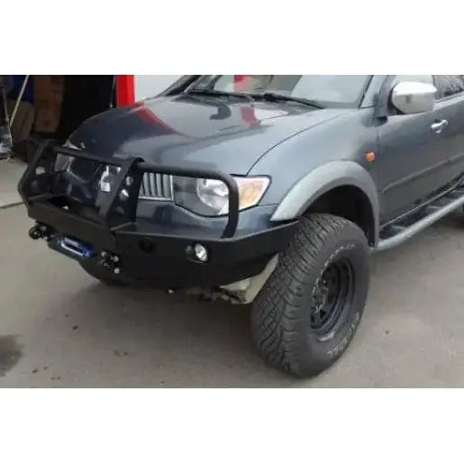 Frontfanger til Mitsubishi L200 IV med bullbar og integrerte lykter, montert på grå pickup.