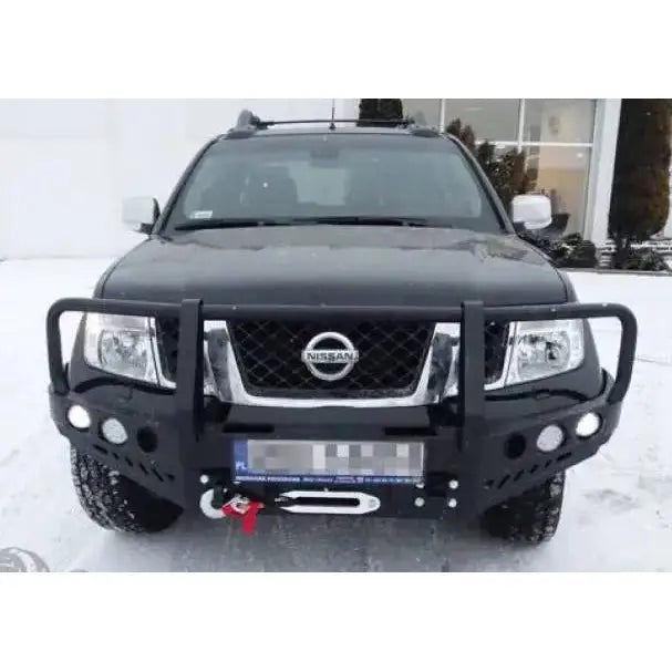 Frontfanger på sort Nissan Navara D40 med bullbar og vinsj, fotografert forfra i vintermiljø.