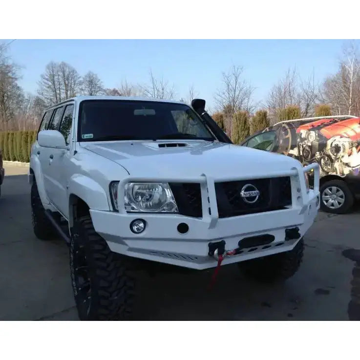Frontfanger på Nissan Patrol Y61 05-13 med bullbar, løftebøyle og grovmønstrede dekk sett i halvprofil.