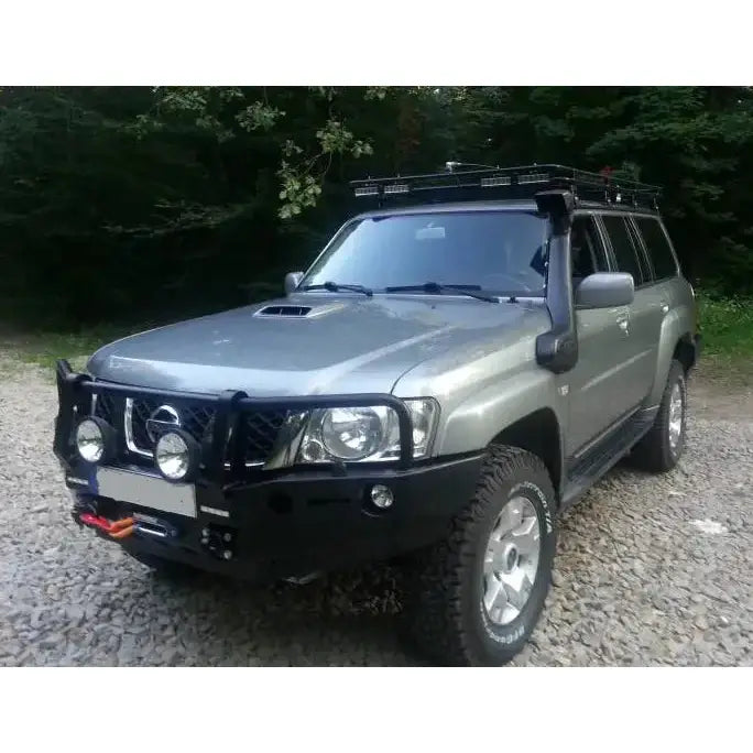 Front bumper på Nissan Patrol Y61 med bullbar, ekstralys og takgrind, fotografert skrått forfra ute.