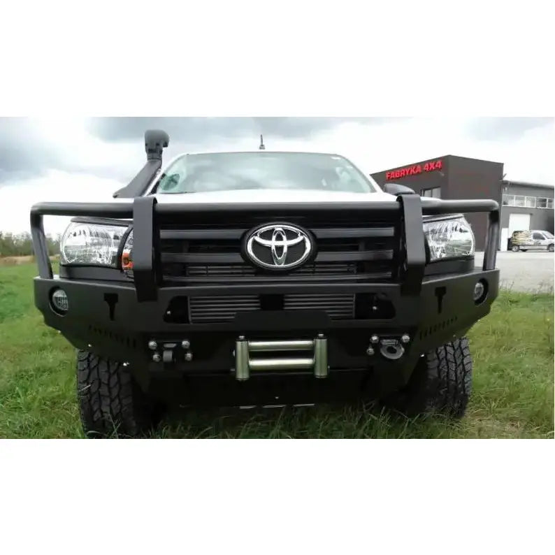 Front bumper av svart stål med bullbar montert på Toyota Hilux Revo, sett rett forfra med vinsjfeste.