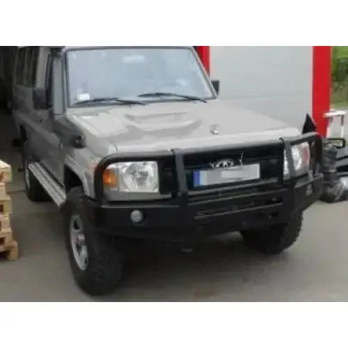 Støtfanger foran med bullbar på grå Toyota Land Cruiser HZJ78 parkert utendørs med stålfelger.