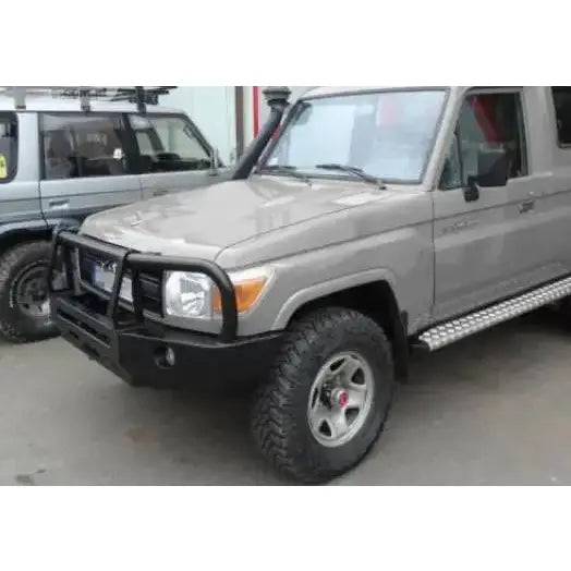 Frontfanger på Toyota Land Cruiser HZJ78 med bullbar, terrengdekk og stigtrinn sett forfra fra venstre.