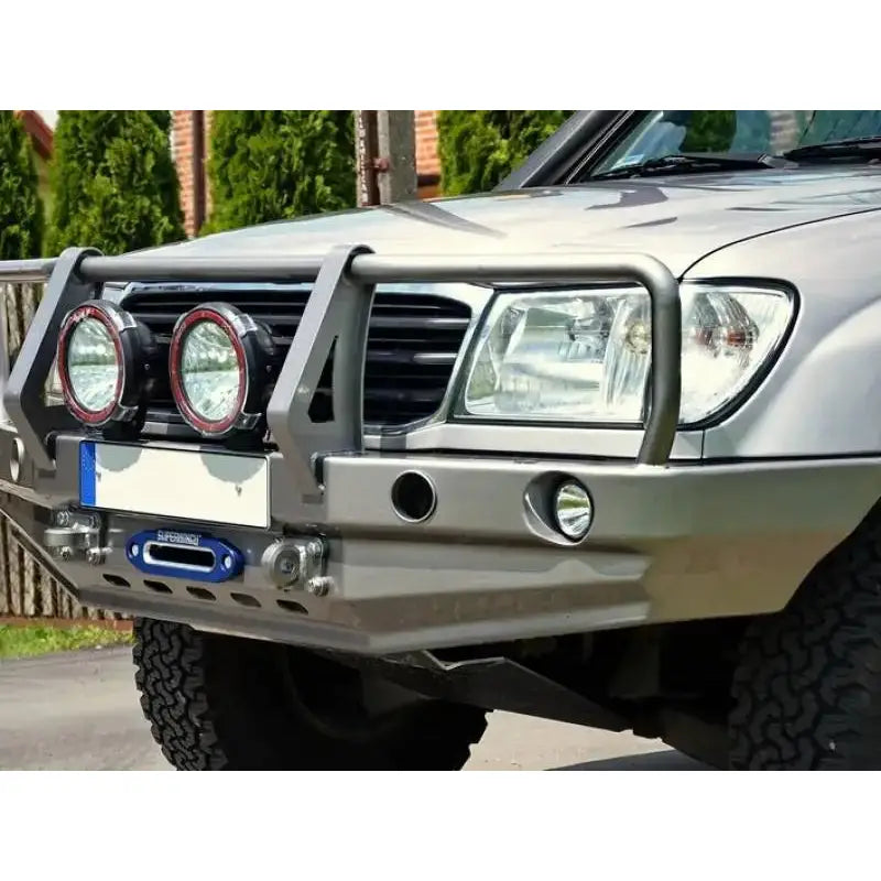 Frontfanger til Toyota Land Cruiser J100 med bullbar og ekstralys, nærbilde fra skrå vinkel på terrengbil.