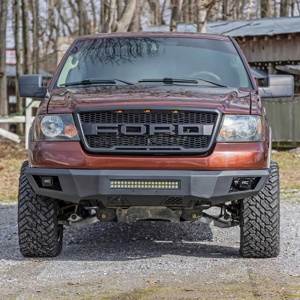Front bumper på Ford F150 med LED-belysning fra Rough Country, sett forfra med grove terrengdekk.