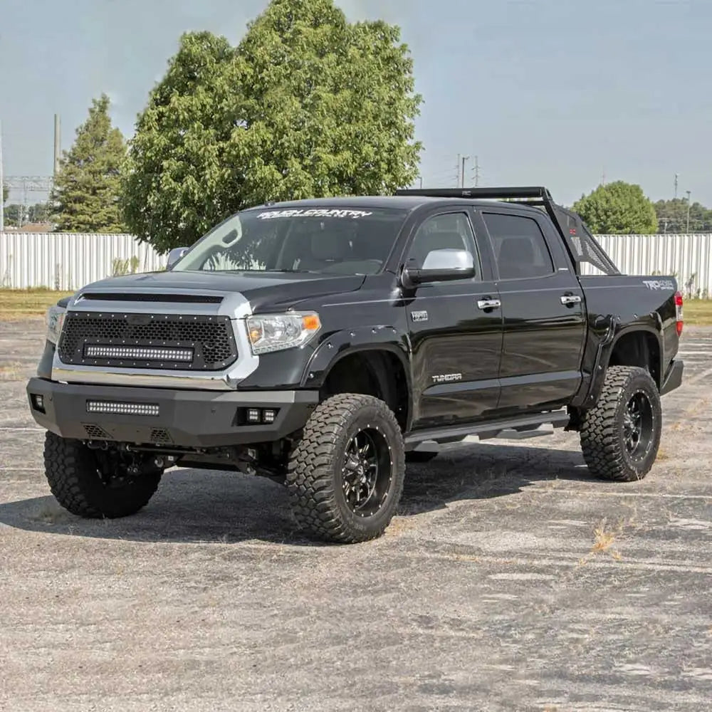 Frontbumper med LED-lys Rough Country montert på svart Toyota Tundra med terrengdekk, skrå forside.