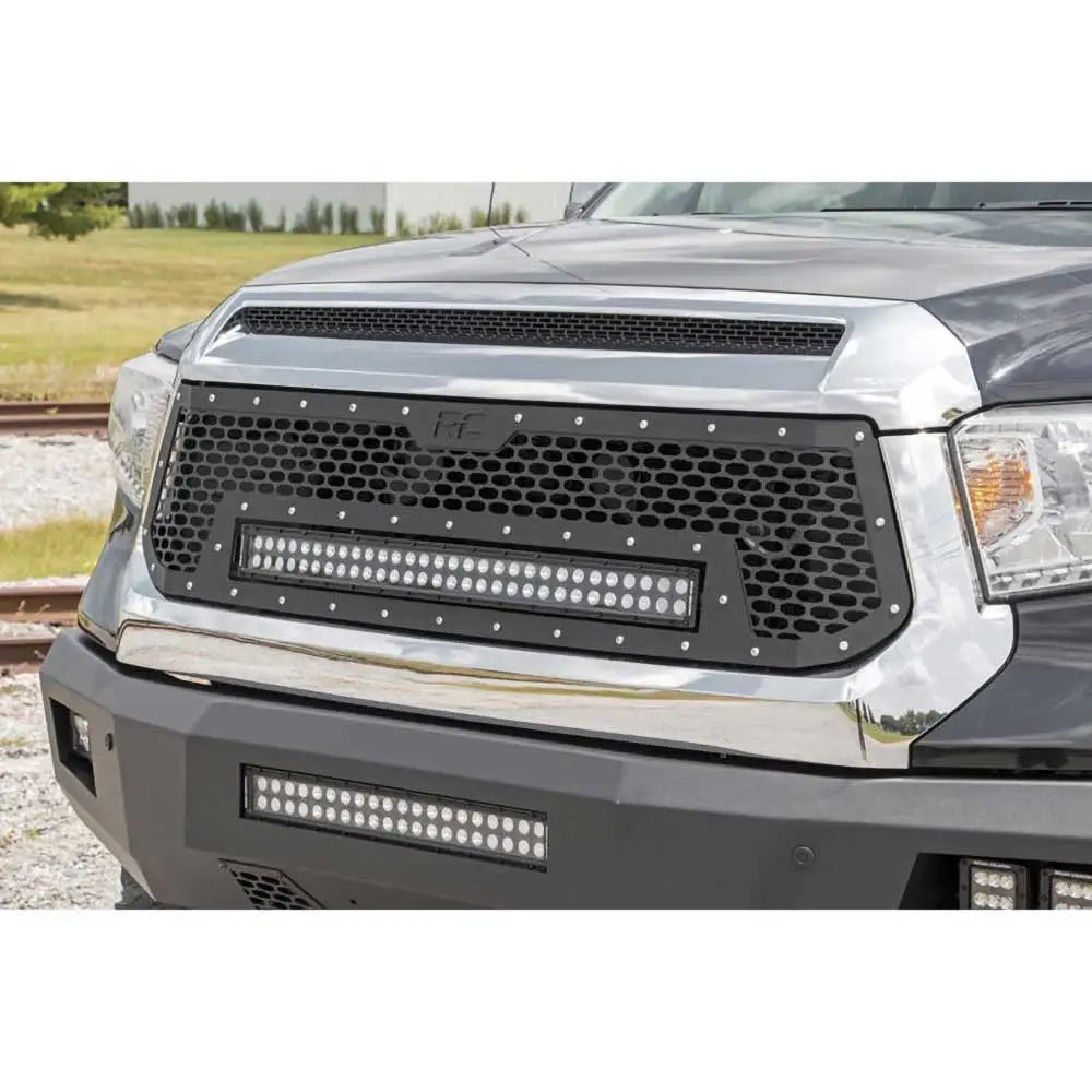 Frontfanger Rough Country med LED-lys på grå Toyota Tundra, bikakemønstret grill sett forfra og fra siden.