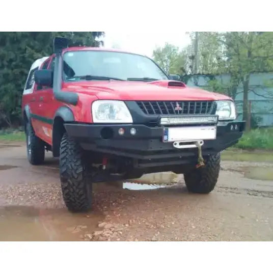 Støtfanger foran på Mitsubishi L200 III med vinsj, snorkel og store terrengdekk sett fra fronten.