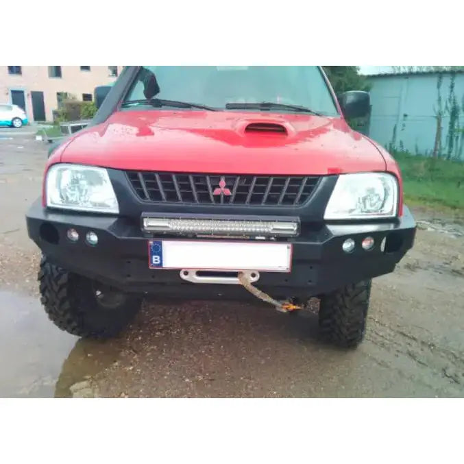 Frontfanger på Mitsubishi L200 III med sort metall, LED-lysbar, taukrok og terrengdekk sett forfra.