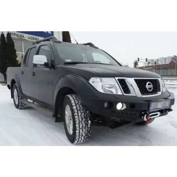 Frontfanger på Nissan Navara D40 med ekstra lykter og vinsj, fotografert skrått forfra på snødekt vei.