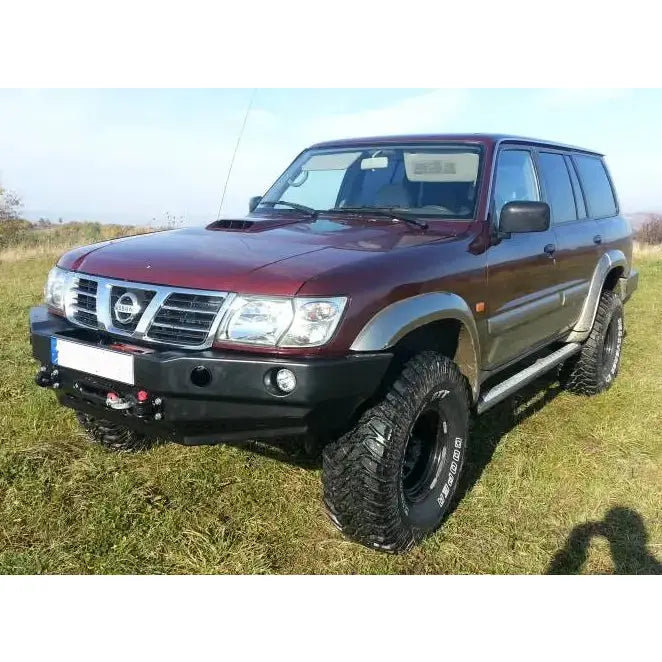 Front bumper på Nissan Patrol Y61 97-04 montert på mørkerød SUV med sorte felger og grove terrengdekk.