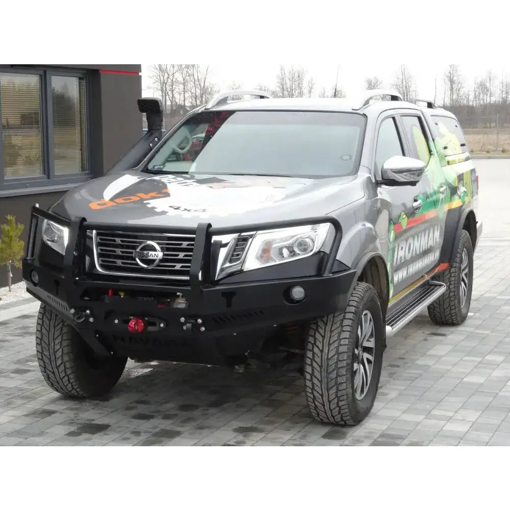 Støtfanger foran av stål med bullbar montert på grå Nissan Navara D23, sett forfra med synlig logo.