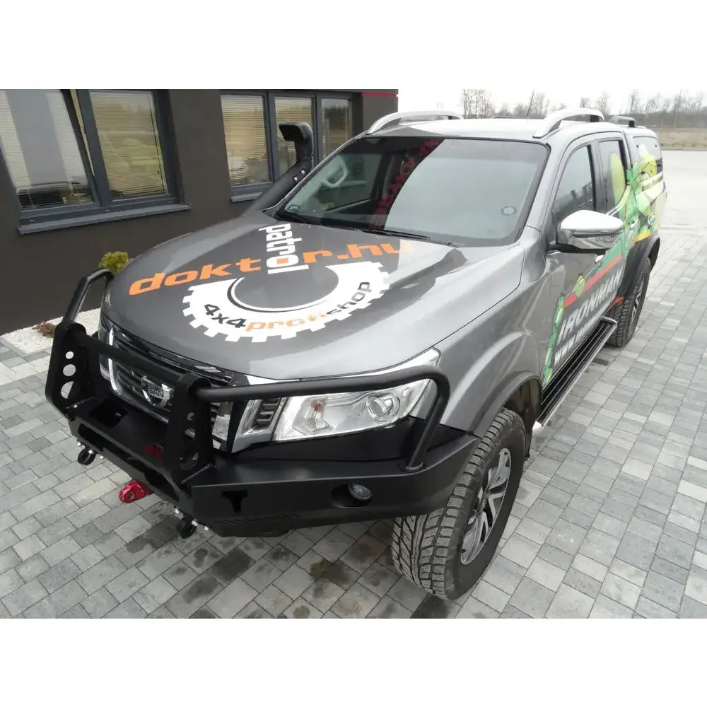 Frontfanger av stål med bullbar og vinsj montert på grå Nissan Navara D23, sett skrått forfra.