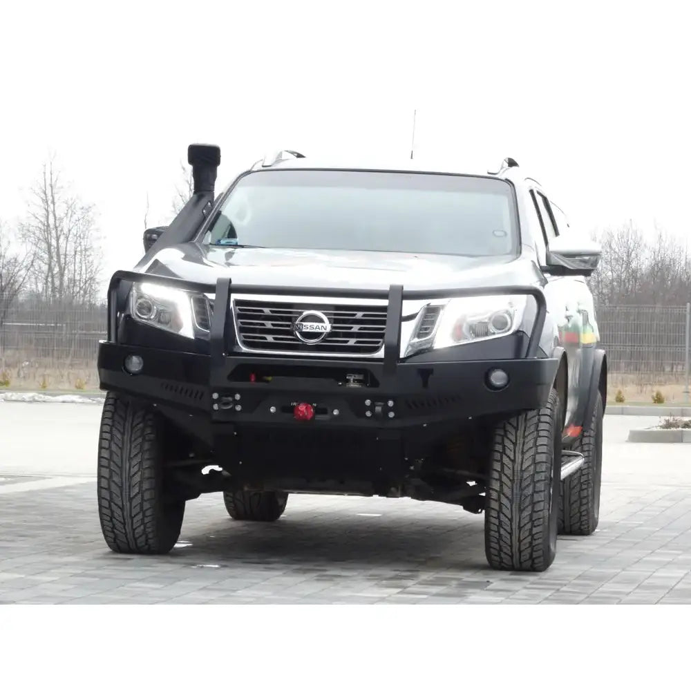 Frontbumper av stål med bullbar på sort Nissan Navara D23 sett forfra med kraftige dekk og grill.