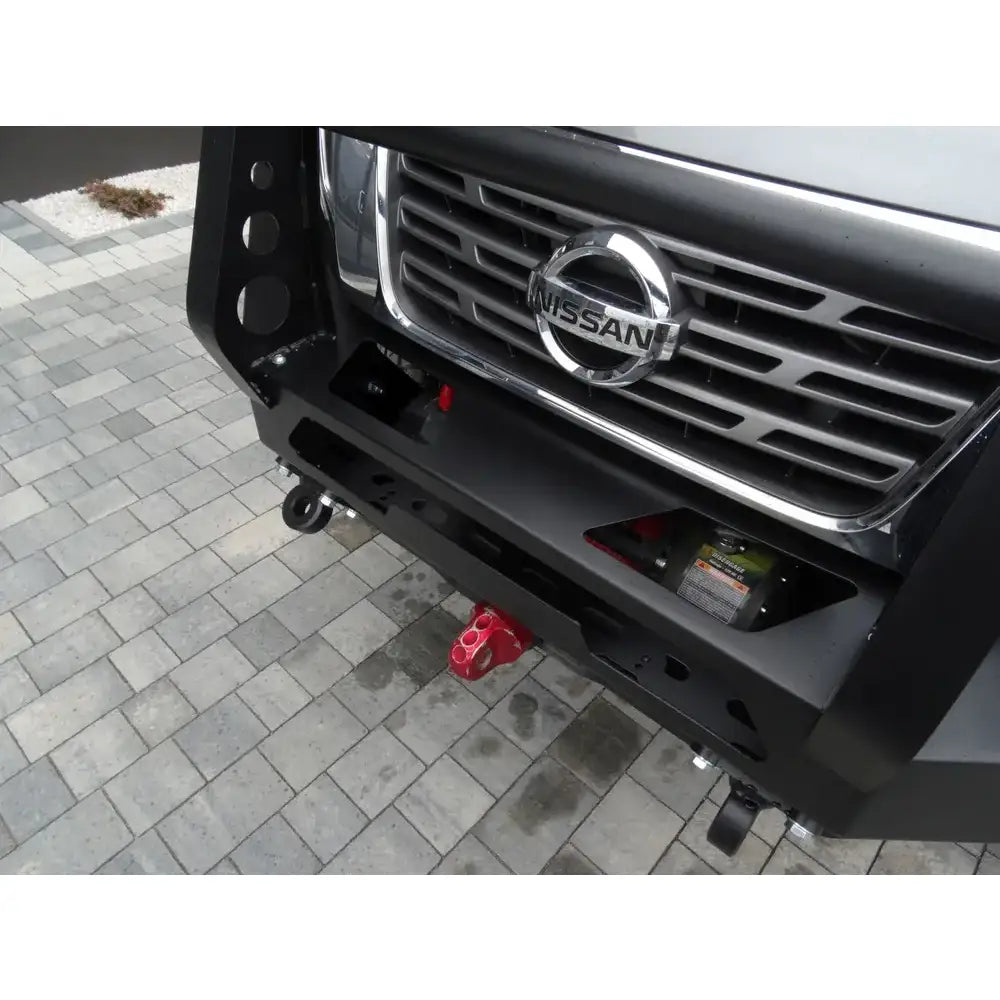 Frontbumper av stål med bullbar til Nissan Navara D23, sett skrått ovenfra med rød krok og vinsj.