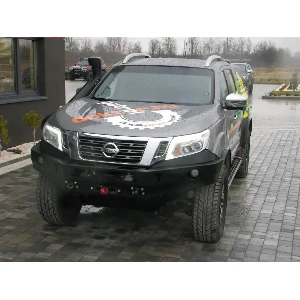 Front bumper på Nissan Navara D23 med kraftig stålfanger og store terrengdekk, avbildet utendørs.
