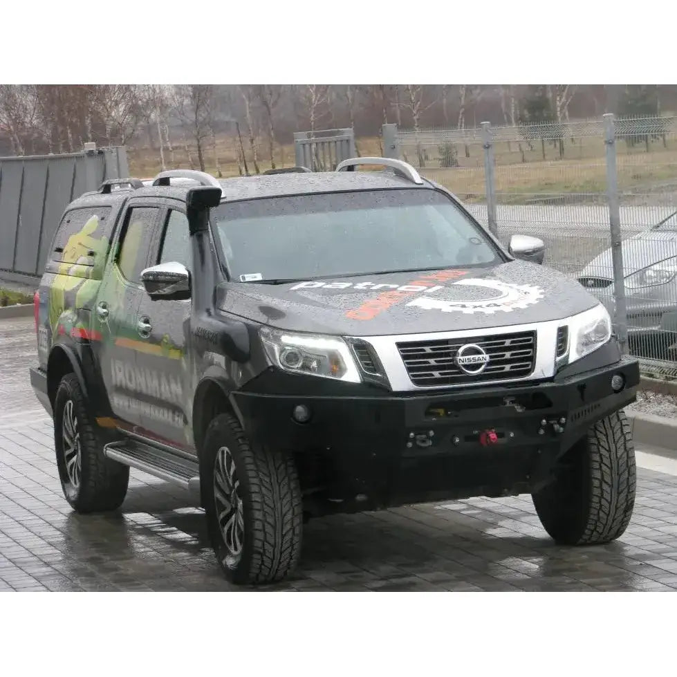Frontfanger på Nissan Navara D23 med sort ståldesign, takrails og snorkel i industrielt uteområde.