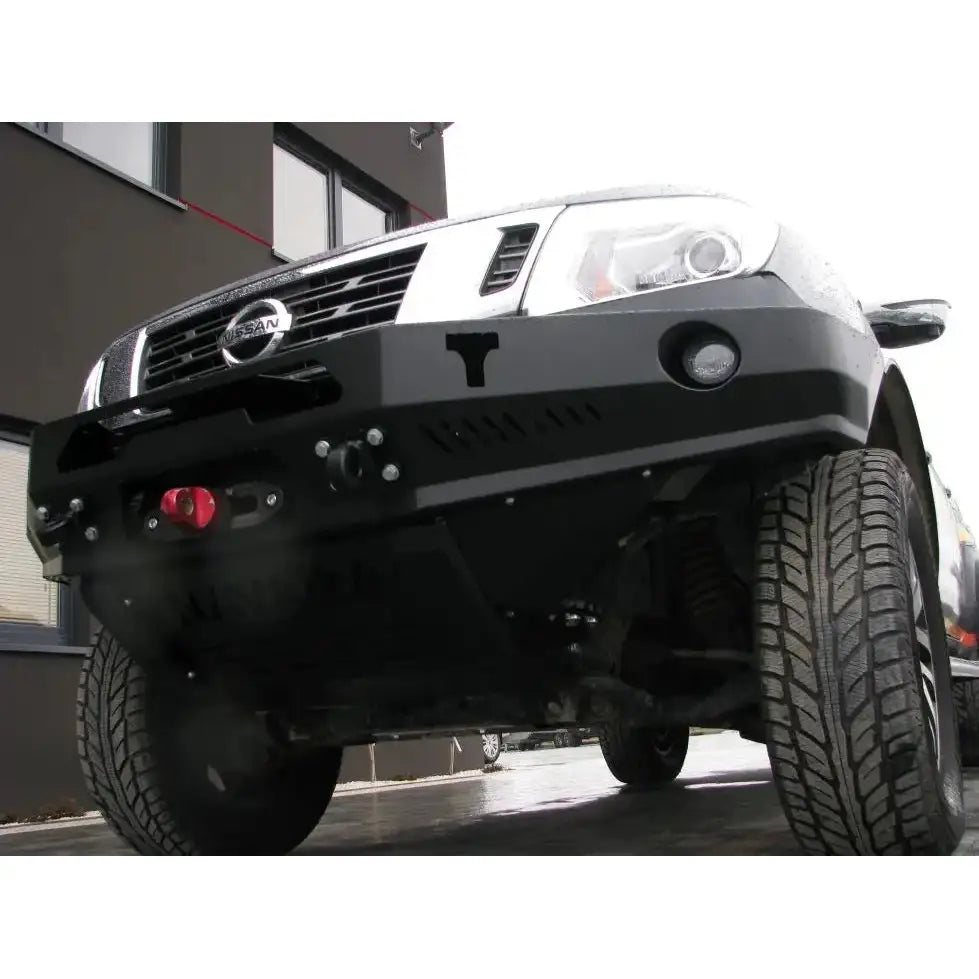 Front bumper av sort stålstøtfanger til Nissan Navara D23 med rød slepekrok og tåkelys, lav vinkel.