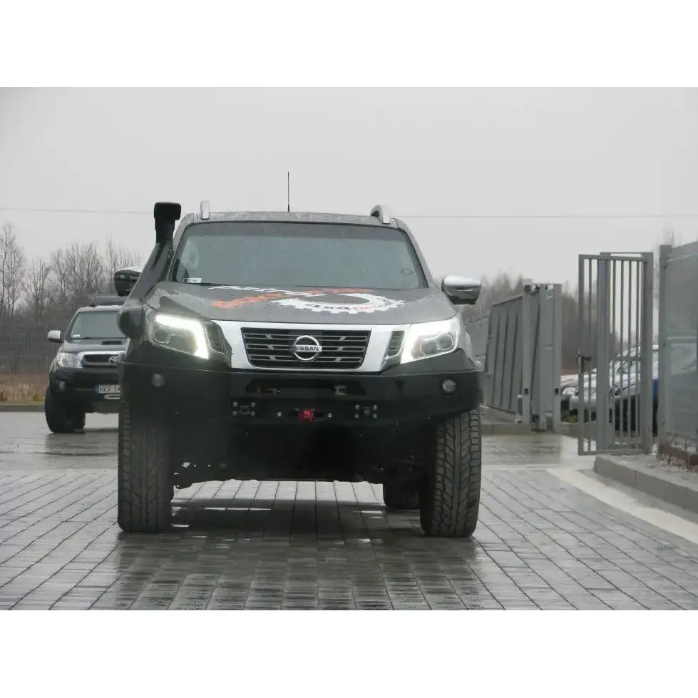 Støtfanger foran av stål montert på Nissan Navara D23, sett rett forfra med LED-lysene tent.