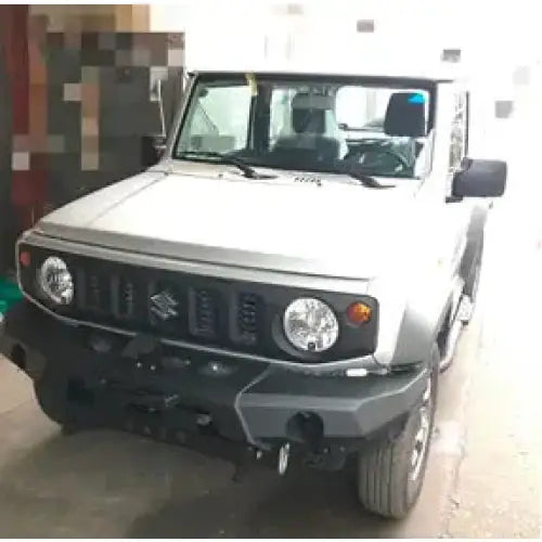 Front bumper av Suzuki Jimny 2018-modell i stål, sett forfra innendørs med tydelige detaljer.