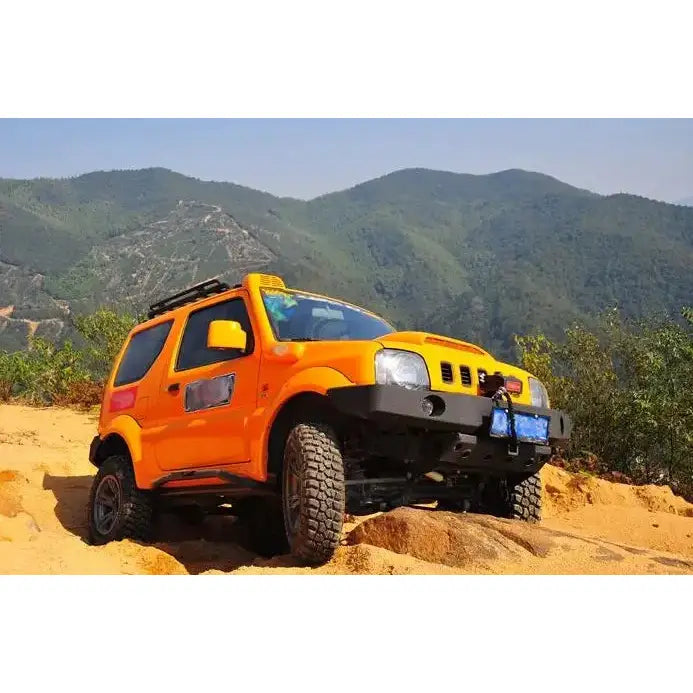 Frontfanger av stål på oransje Suzuki Jimny 97-17 med sorte detaljer i sanddekt terreng.