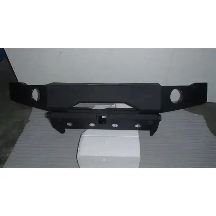 Front bumper av stål for Suzuki Jimny 97-17, vist rett forfra med hull og utsparinger på hvit blokk.