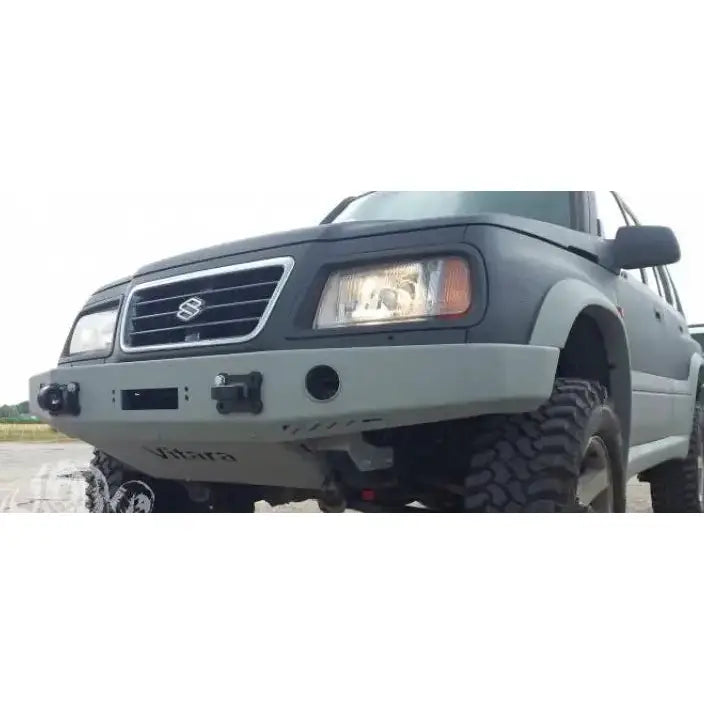 Støtfanger foran til Suzuki Vitara 2.0 V6 95-97, sett forfra med robust grå metallfanger og terrengdekk.