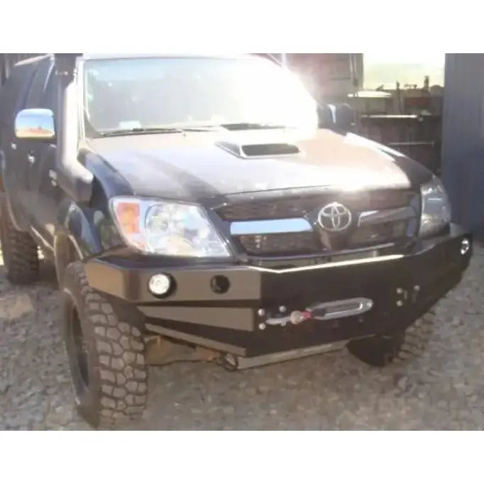 Front bumper på Toyota Hilux 05-11 terrengbil med stålfanger, integrert vinsj og store terrengdekk.