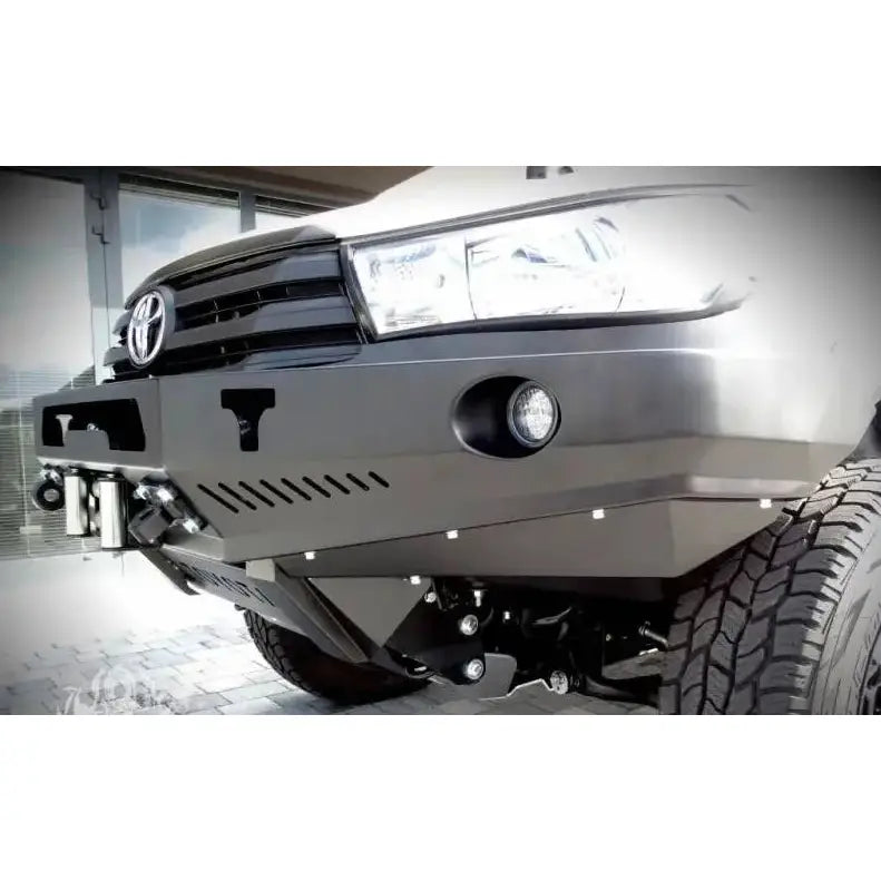 Front bumper til Toyota Hilux Revo 16- i matt svart metall med integrerte lykter, sett skrått forfra.