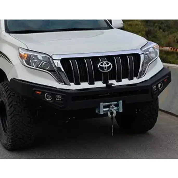 Støtfanger foran til Toyota Land Cruiser 150, sort metall med vinsj og lykter, montert på hvit SUV.