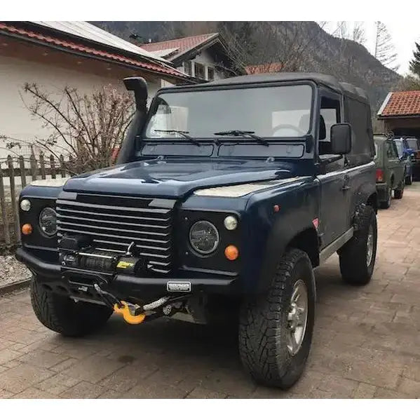 Frontbumper på Land Rover Defender med vinsj, snorkel, svart hardtop og robuste terrengdekk.