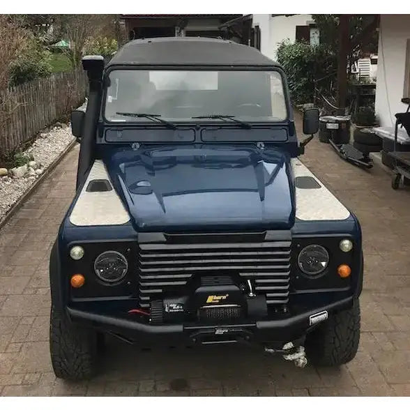 Støtfanger foran på Land Rover Defender med sølvlister, vinsj og svart snorkel, sett rett forfra.