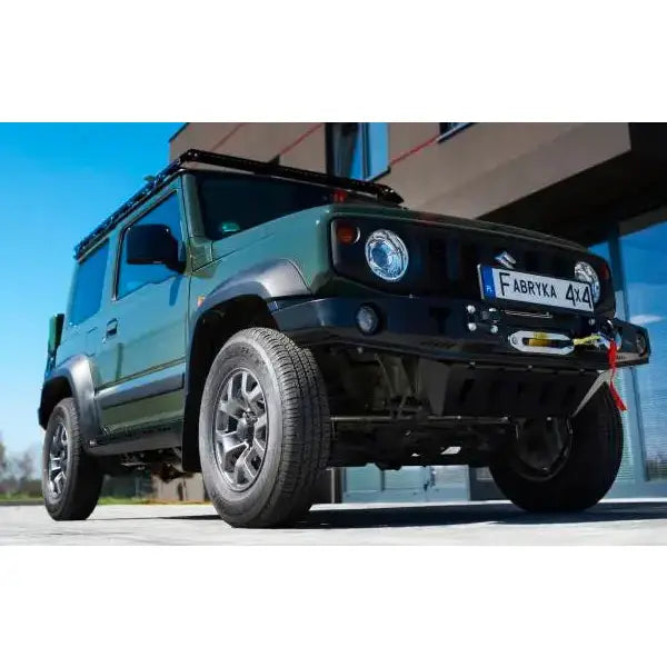 Frontfanger på Suzuki Jimny IV 1.5, mørkegrønn, med vinsj, terrengdekk og svart takgrind.