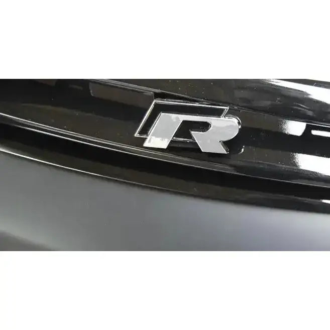 Frontbumper R-emblem på sort blank støtfanger til Vw Scirocco, nærbilde fra skrå vinkel.