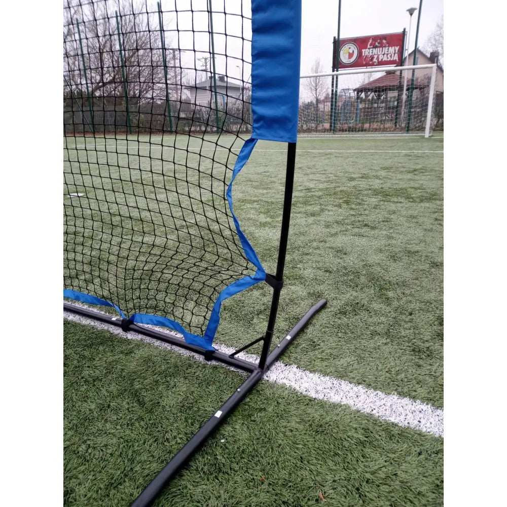 Stuivend Stort Trampoline, detalj av sort og blått treningsnett plassert på kunstgress ved hvit banelinje.