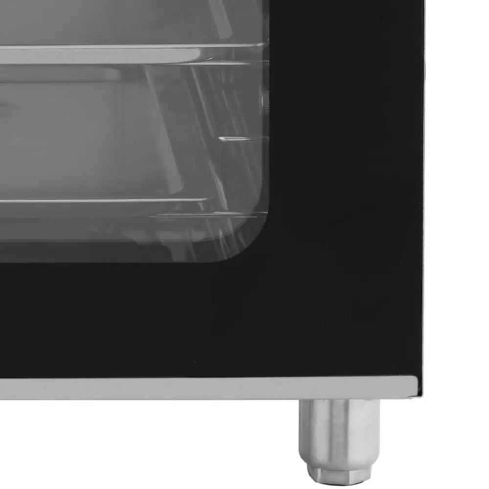 Stykke konveksjonsovn, detalj av nederste hjørne med rund metallfot og synlig metallrist bak glassdøren.