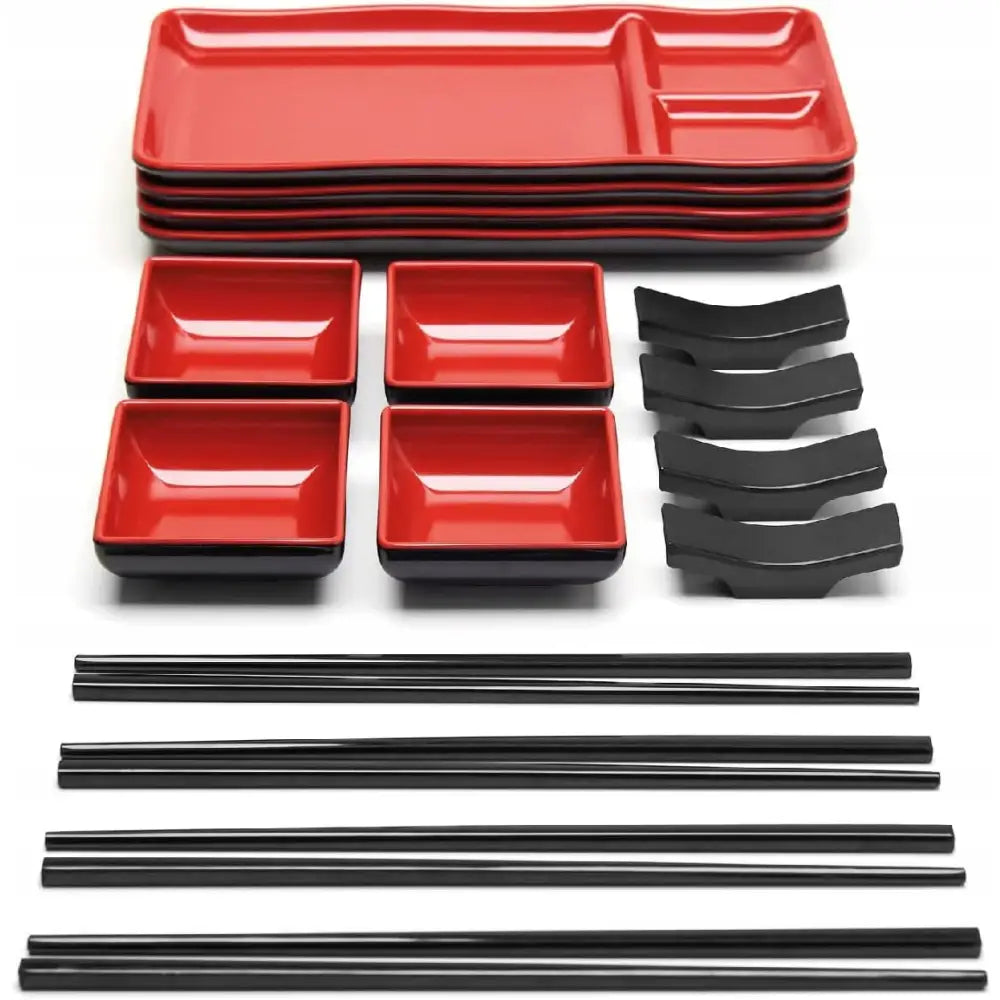 Sushi sett med røde og svarte tallerkener, firkantede skåler og svarte spisepinner arrangert på hvit bakgrunn.