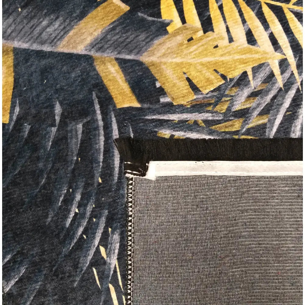 Svart & Gull Tepe, detaljert nærbilde av mørkeblå og gule blader, synlig kant og overlock-søm på baksiden.