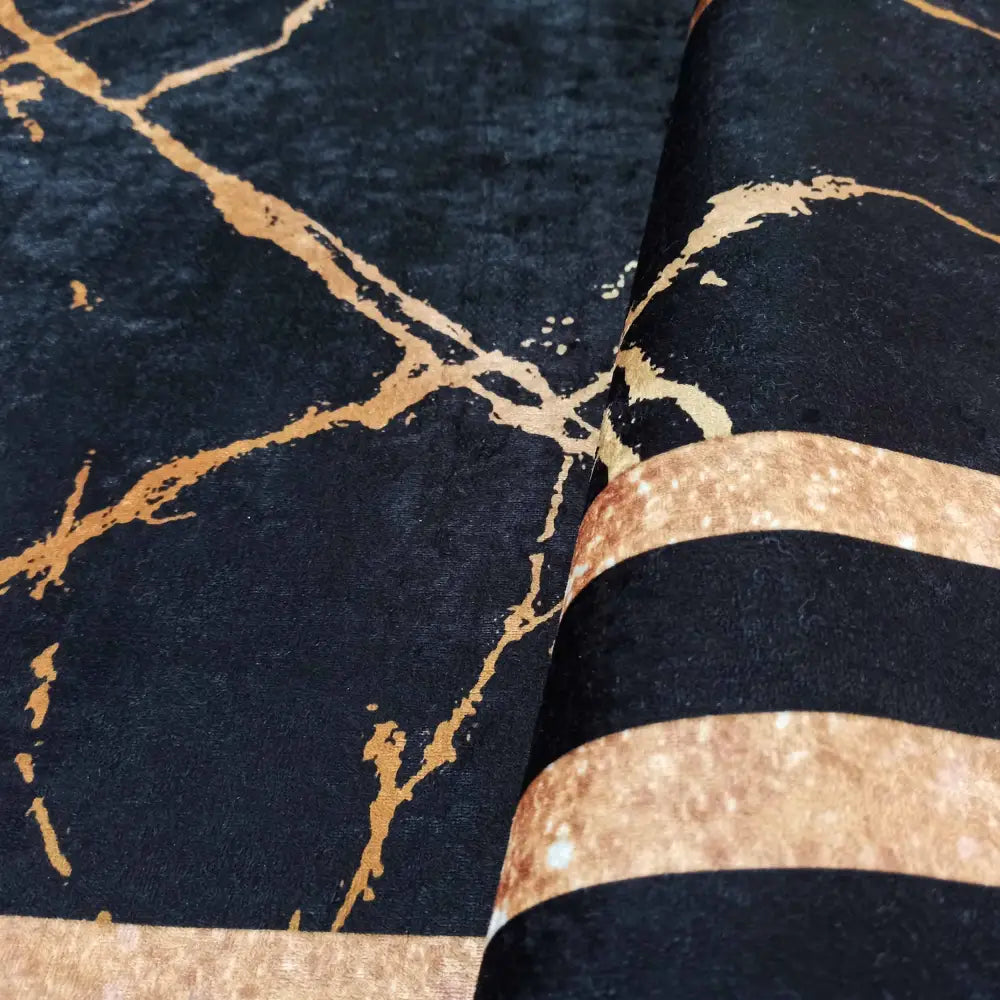 Svart og gull teppe Black Gold, nærbilde som fremhever gullmarmor og teksturert, myk flate.