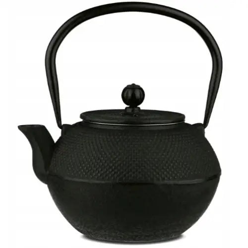Svart tekanne i støpejern med grov tekstur, buet håndtak og dekorativ knott på lokket, sett fra siden.