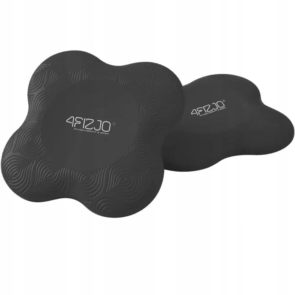 Svarte blomsterformede yoga knær- og albueputer i skum med bølgemønster og hvit logo, sett ovenfra.