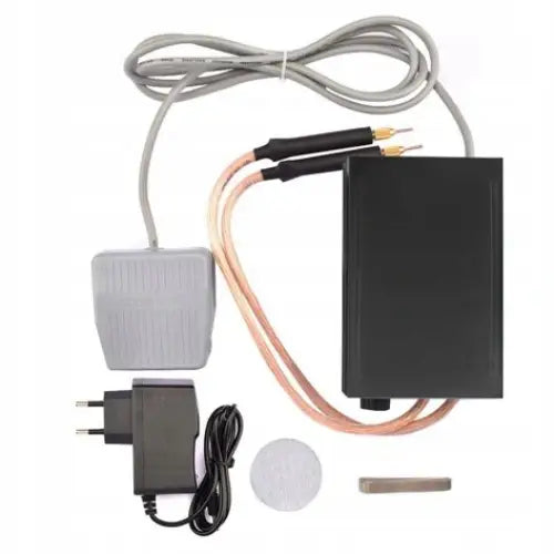 Sveiseapparat for hjemmebruk med sort boks, grå fotpedal, ledninger, strømadapter og tilbehør på hvit bakgrunn.