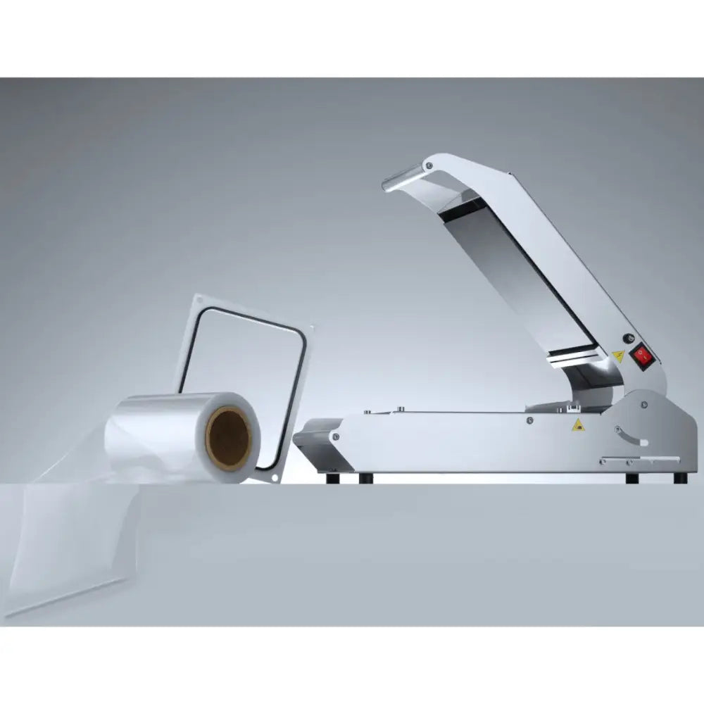 Sveisemaskin for brett og kopper med PE-matrise, sidevisning med åpent lokk og plastfilm-rull ved siden av.