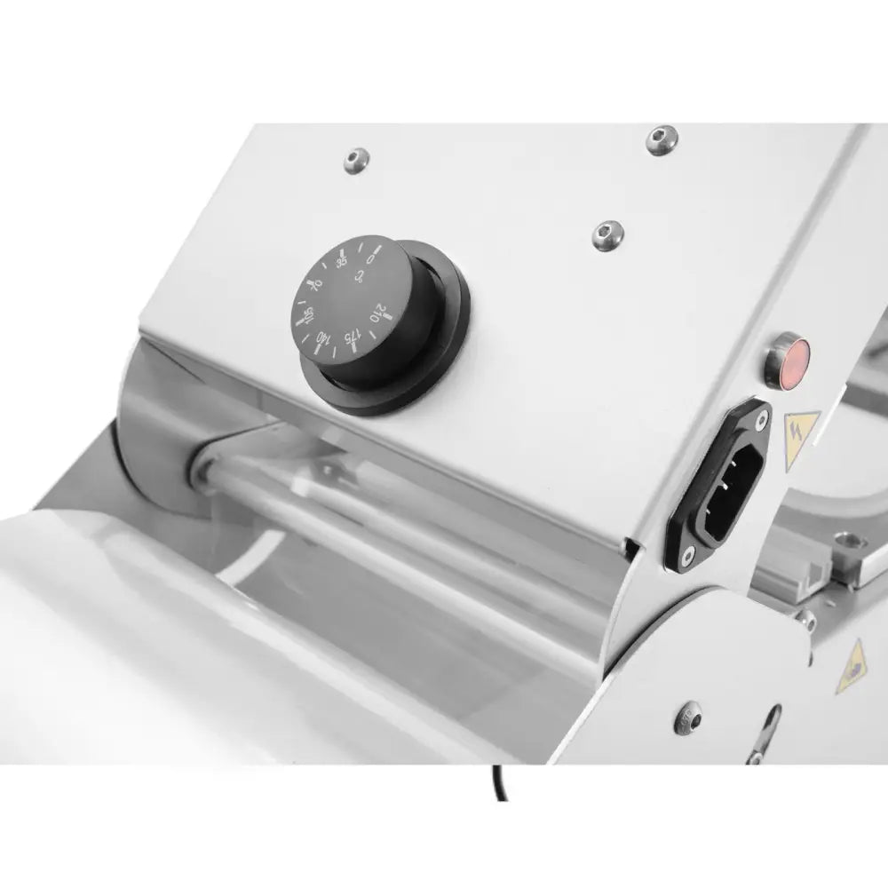 Sveisemaskin for takeaway matbeholdere, nærbilde av sort innstillingsknapp, rullede metalldeler og strøminngang.