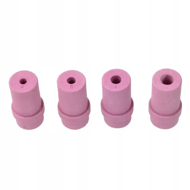 Fire rosa keramikkdeler til sandblåser, skrå oversiktsvinkel viser sirkulære hull og tydelige markeringer.