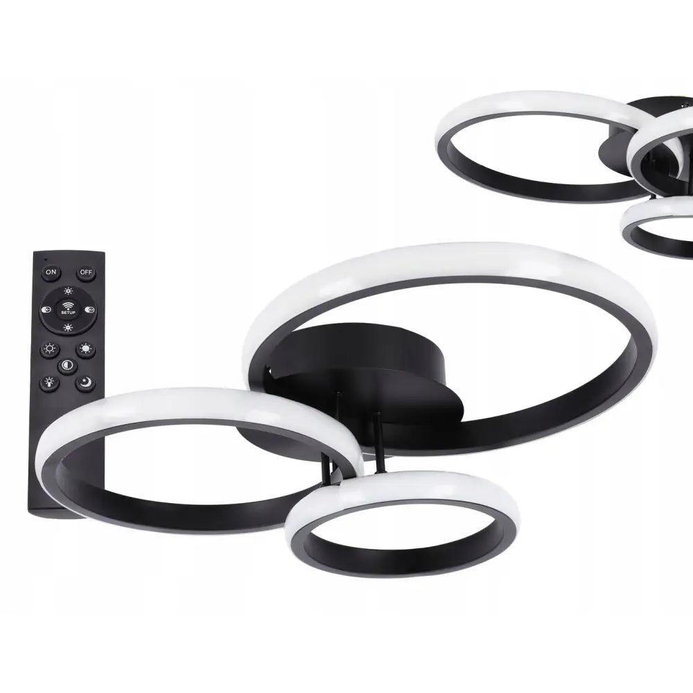 Moderne LED taklampe i sort metall med tre hvite sirkulære lysringer, vist fra skrå vinkel med fjernkontroll.
